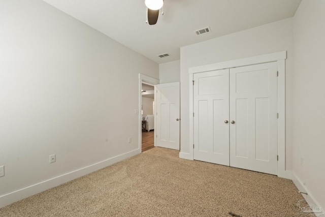 unfurnished bedroom featuring ceiling fan, a closet, and carpet flooring