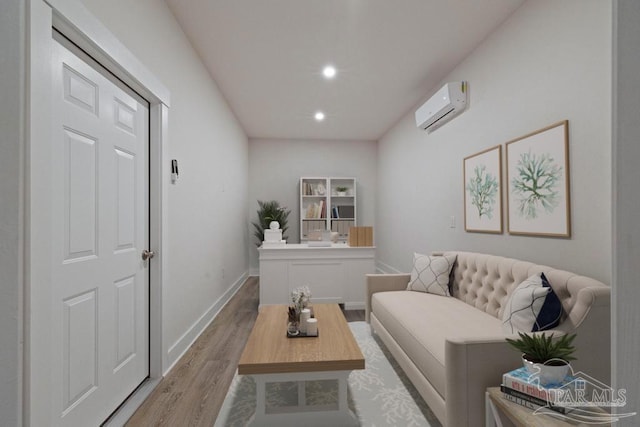 living room featuring a wall mounted air conditioner and light hardwood / wood-style flooring