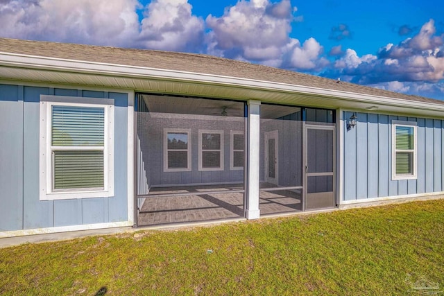 back of house featuring a yard and a sunroom