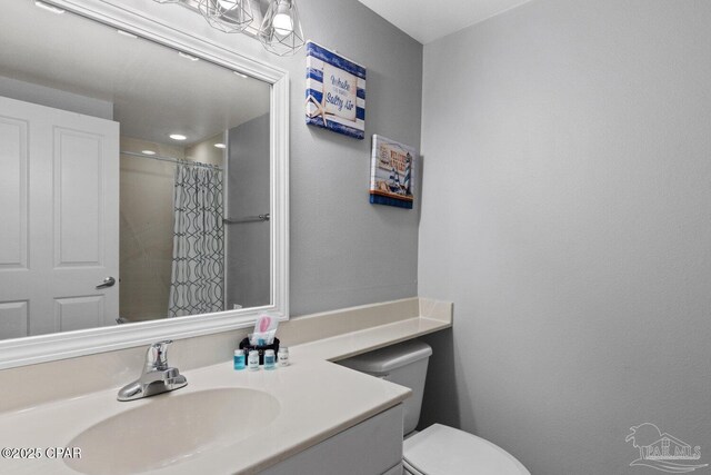 bathroom with vanity, a shower with shower curtain, and toilet