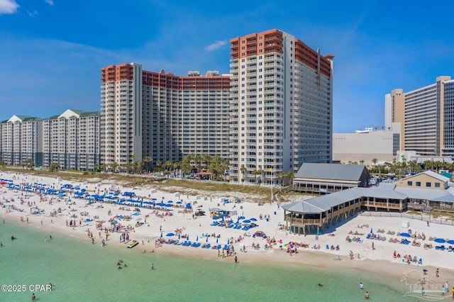 view of building exterior featuring a city view, a view of the beach, and a water view