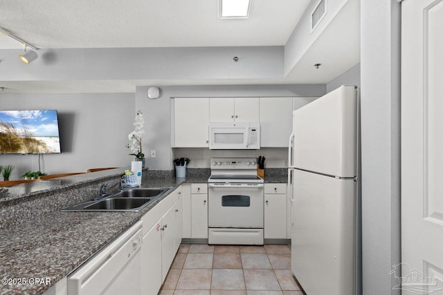 kitchen featuring visible vents, white cabinetry, a sink, and white appliances