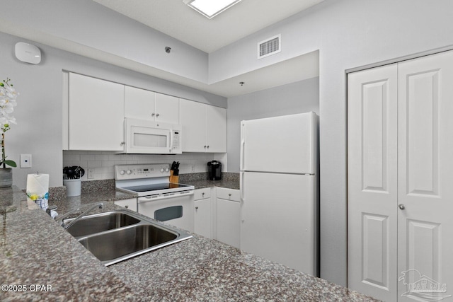 kitchen with a sink, dark countertops, visible vents, white cabinetry, and white appliances