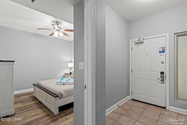 entryway featuring ceiling fan, baseboards, and light wood finished floors