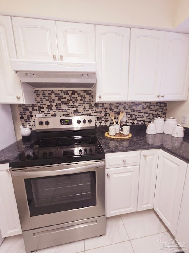 kitchen with under cabinet range hood, stainless steel electric range, white cabinetry, and backsplash