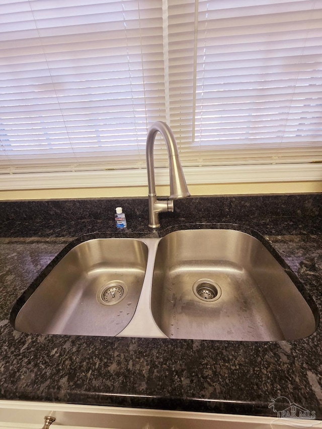 details featuring dark stone countertops and a sink