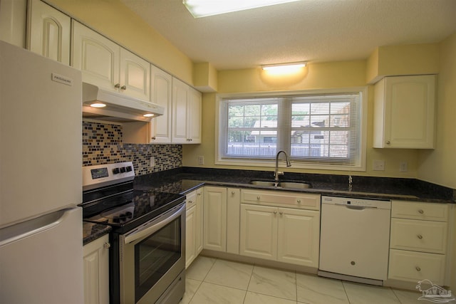 kitchen featuring white appliances, under cabinet range hood, white cabinets, and a sink