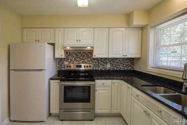 kitchen featuring freestanding refrigerator, stainless steel range with electric stovetop, white cabinetry, a sink, and exhaust hood