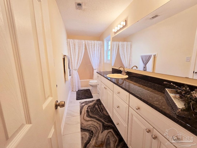 bathroom with a textured ceiling, visible vents, vanity, and toilet