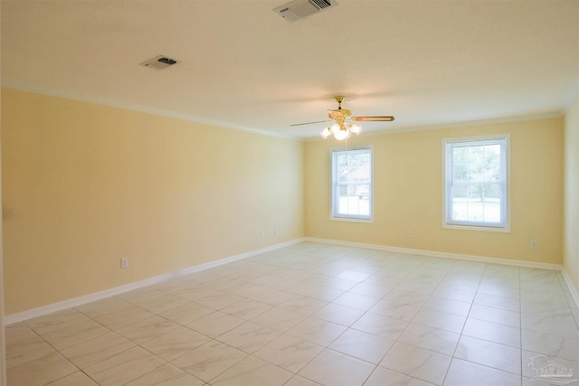 spare room featuring baseboards, visible vents, and crown molding