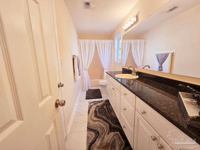 full bathroom featuring toilet, visible vents, a textured ceiling, and vanity