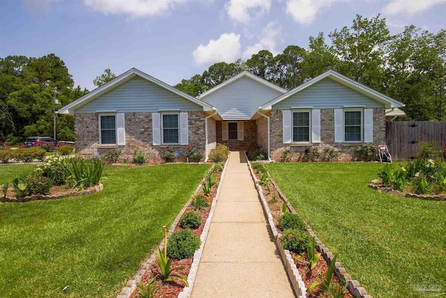 ranch-style home with brick siding, a front yard, and fence