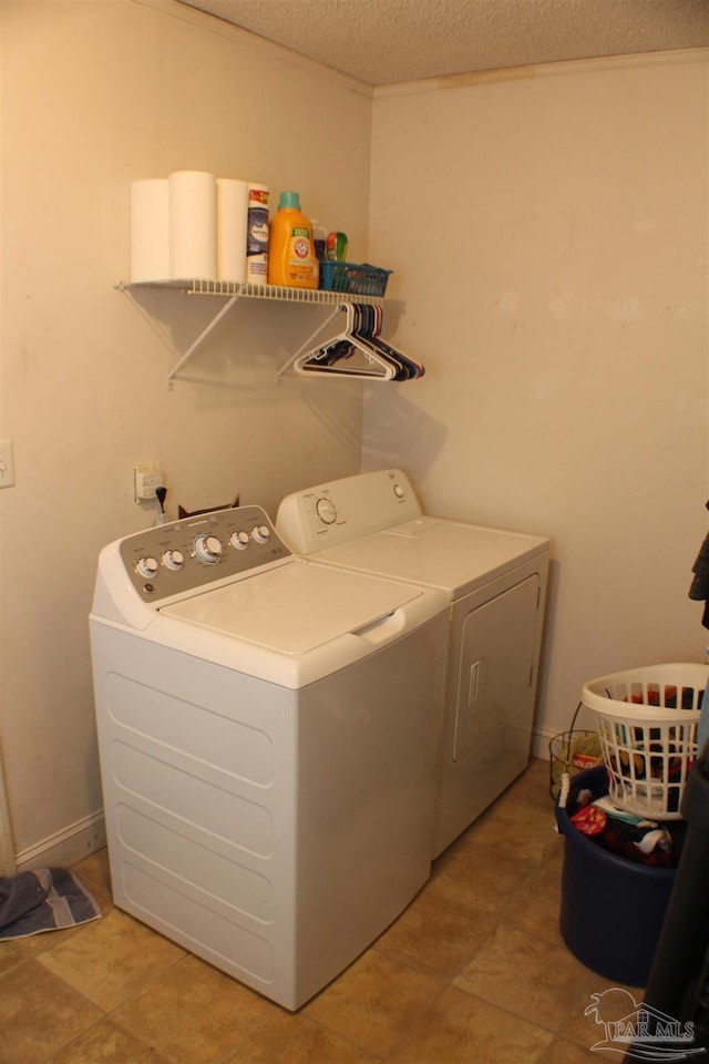 laundry area featuring a textured ceiling and washer and dryer