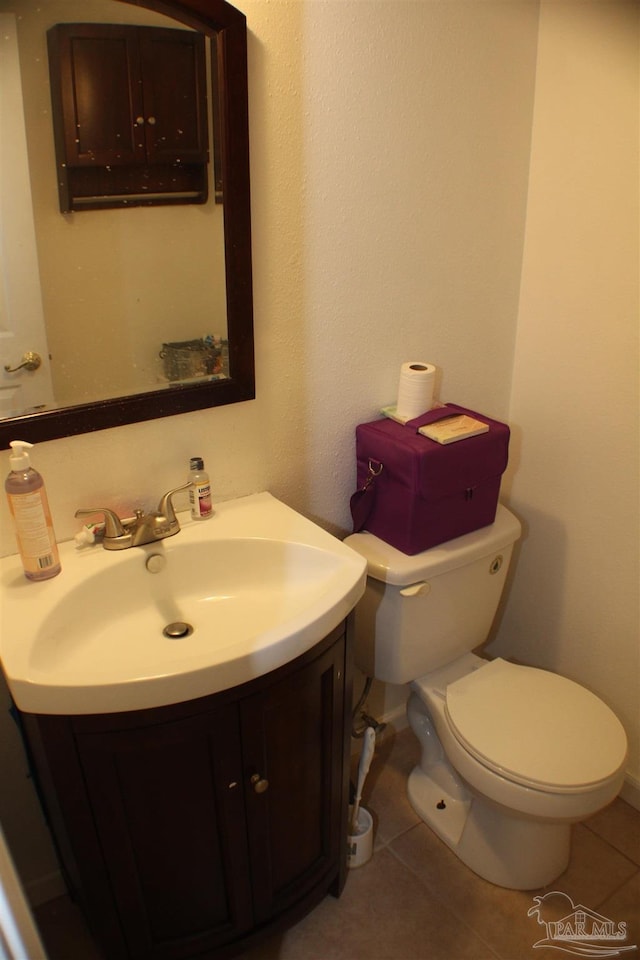 bathroom with toilet, tile patterned flooring, and vanity