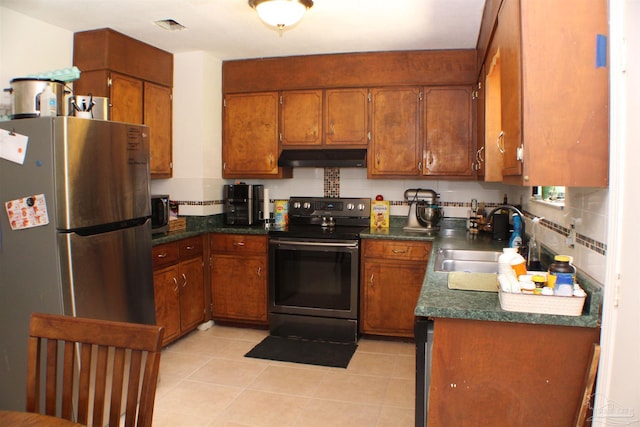 kitchen featuring stainless steel appliances, tasteful backsplash, light tile patterned floors, and sink