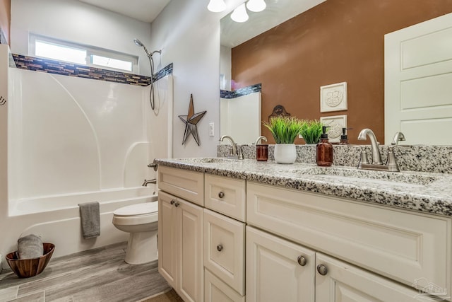 full bathroom featuring bathing tub / shower combination, toilet, vanity, and wood-type flooring