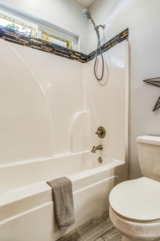 bathroom featuring shower / washtub combination and toilet