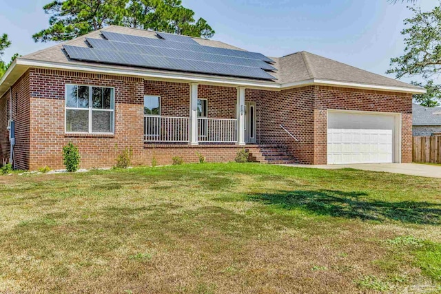 view of front of property featuring a front lawn, solar panels, and a garage