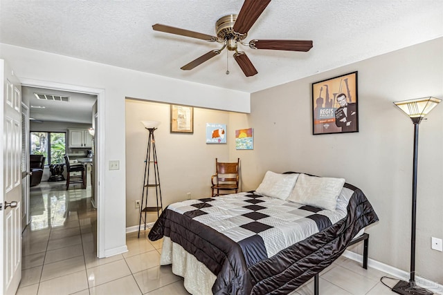 bedroom featuring light tile patterned floors, a textured ceiling, and ceiling fan