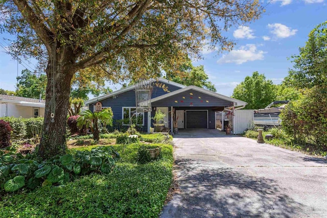 mid-century inspired home featuring a garage, concrete driveway, and a carport