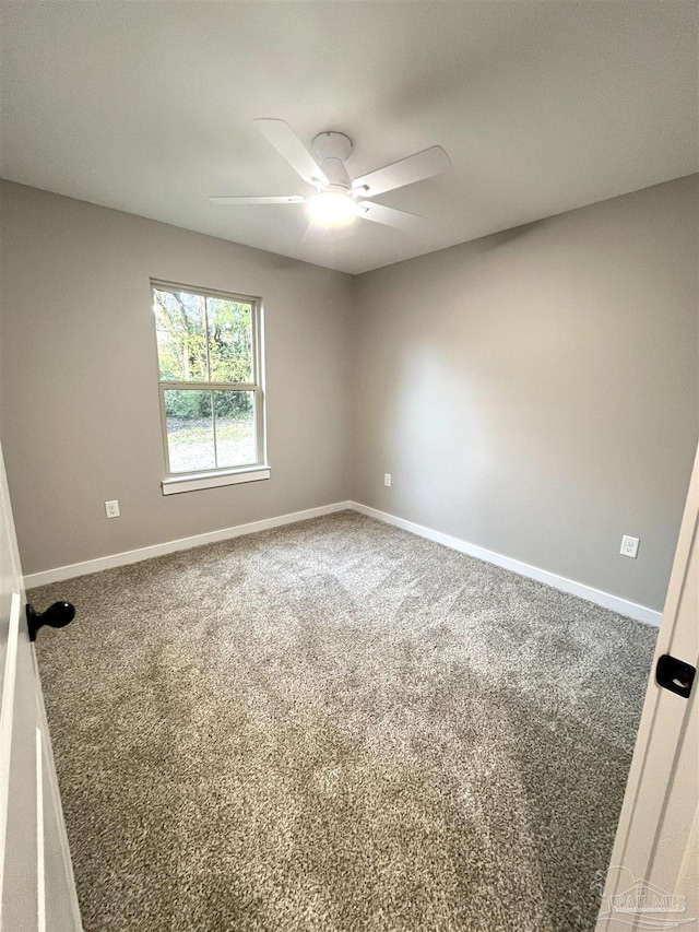 carpeted spare room featuring ceiling fan