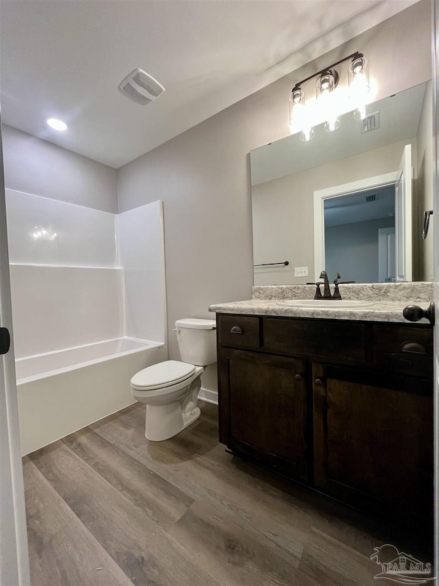 full bathroom with shower / bathing tub combination, vanity, toilet, and wood-type flooring