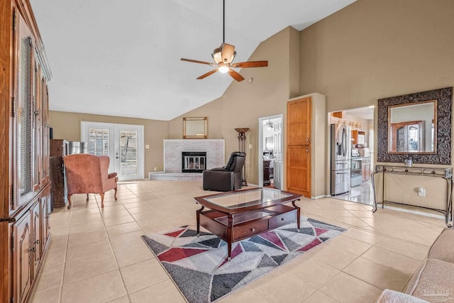 tiled living room featuring a brick fireplace, high vaulted ceiling, french doors, and ceiling fan