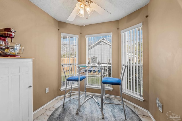 tiled dining room with a textured ceiling, ceiling fan, and a wealth of natural light