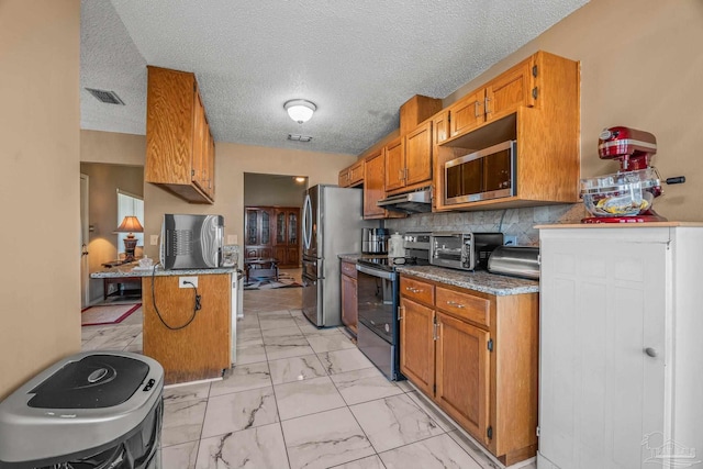 kitchen with stainless steel appliances, decorative backsplash, a textured ceiling, and a kitchen breakfast bar