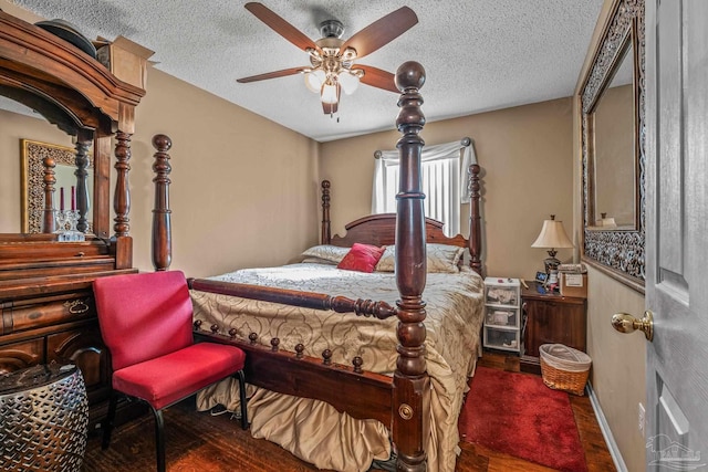 bedroom featuring dark wood-type flooring, a textured ceiling, and ceiling fan