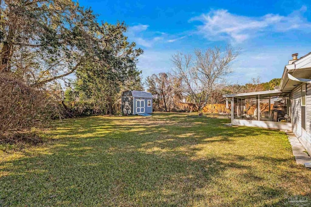 view of yard with a sunroom and a storage shed