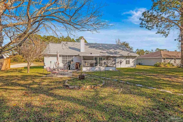 back of house featuring a lawn and a patio