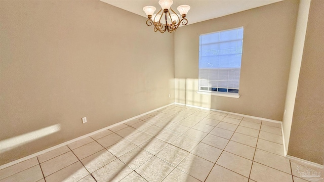 unfurnished room featuring baseboards, a notable chandelier, and light tile patterned flooring