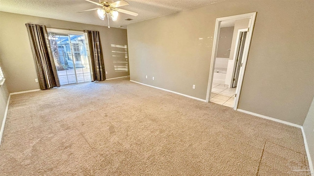 unfurnished bedroom featuring access to outside, light carpet, a textured ceiling, and ensuite bathroom