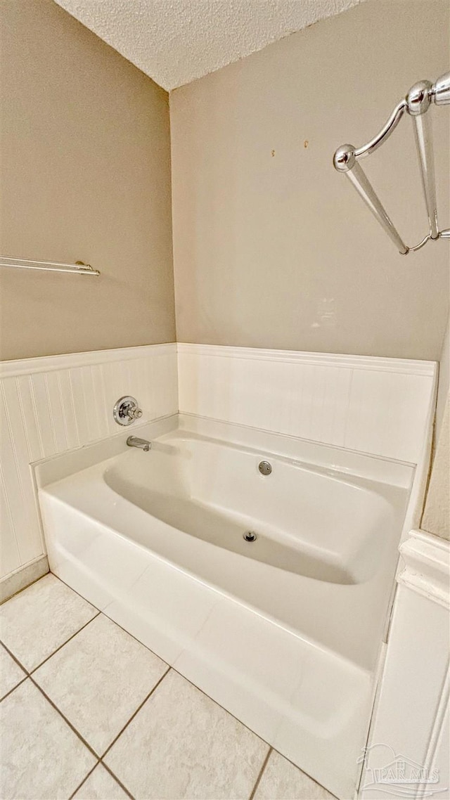 full bathroom with a bath, tile patterned flooring, and a textured ceiling