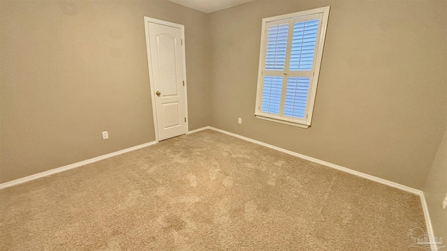 carpeted spare room featuring baseboards