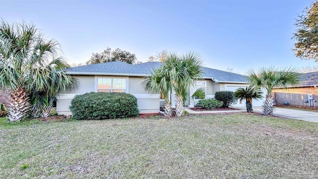 view of front of property featuring a garage, stucco siding, concrete driveway, and a front yard