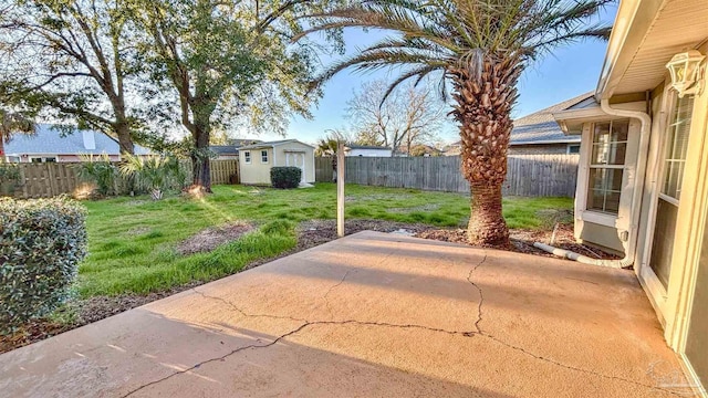 view of patio / terrace with a storage shed, a fenced backyard, and an outbuilding