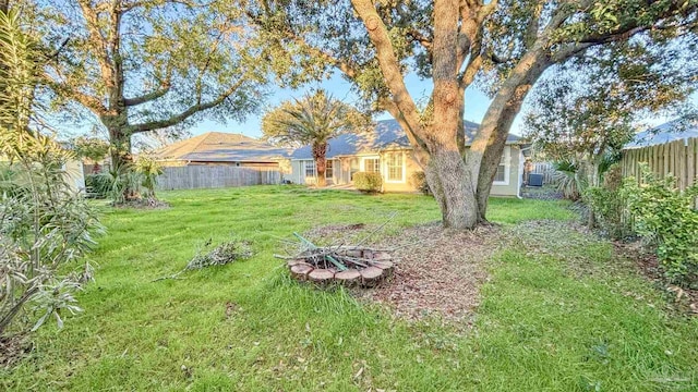 view of yard with a fenced backyard and a fire pit