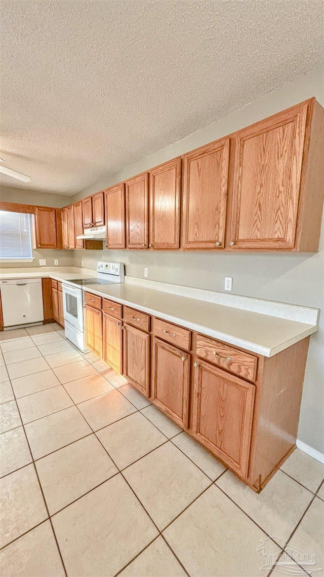 kitchen featuring white appliances, light tile patterned floors, and light countertops