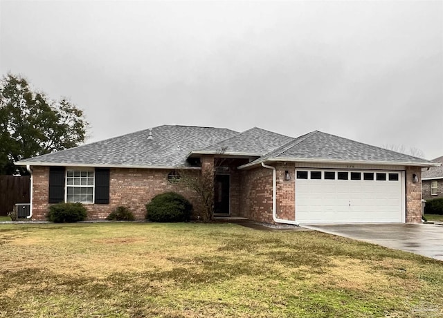 view of front of home with a front yard, a garage, and central AC