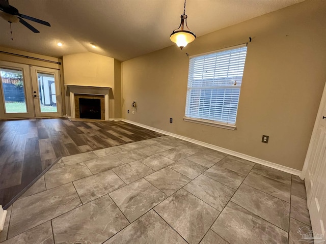 unfurnished living room with ceiling fan, french doors, and vaulted ceiling