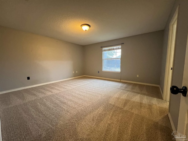 carpeted empty room with a textured ceiling