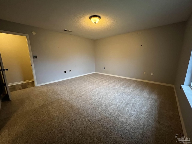 carpeted spare room featuring a textured ceiling