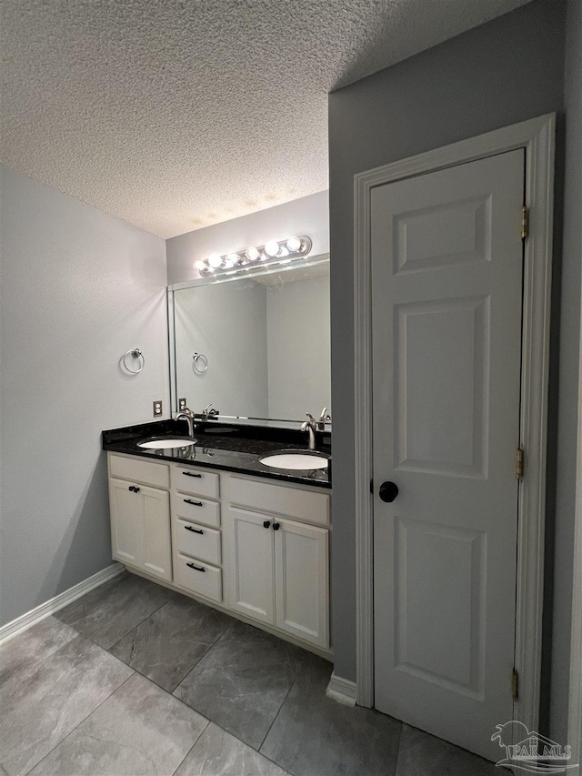 bathroom with a textured ceiling and vanity