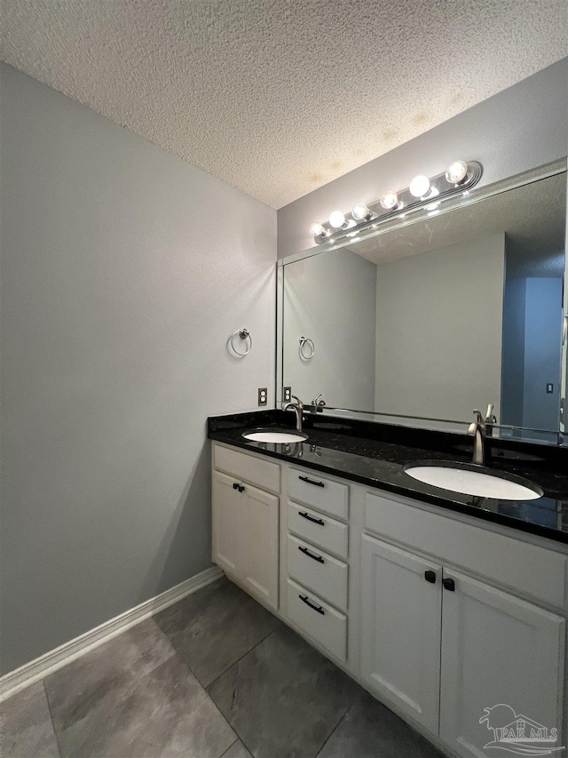 bathroom featuring a textured ceiling and vanity