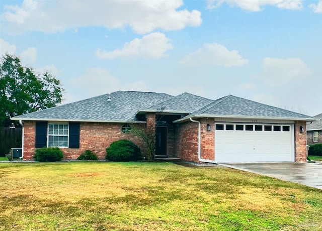 view of front of house with a garage, central AC, and a front lawn