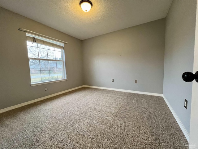 carpeted spare room featuring a textured ceiling