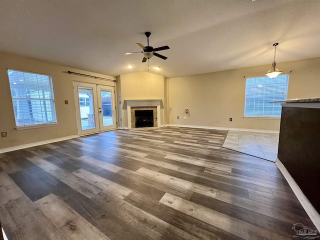 unfurnished living room featuring vaulted ceiling, french doors, ceiling fan, and hardwood / wood-style floors