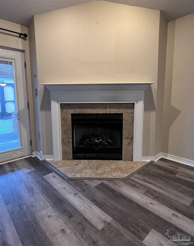 interior details with a textured ceiling, a fireplace, and hardwood / wood-style flooring